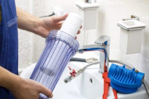 a plumber installs a water filter in burlington